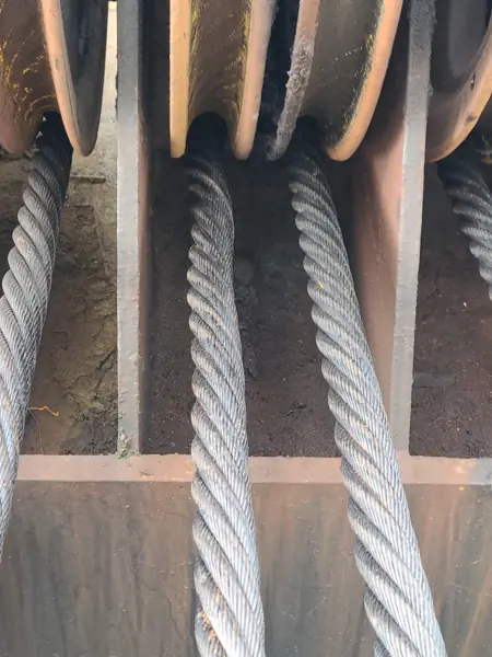 Wire rope leaving tight sheaves on a Clyde barge crane block, being forced into a corkscrew