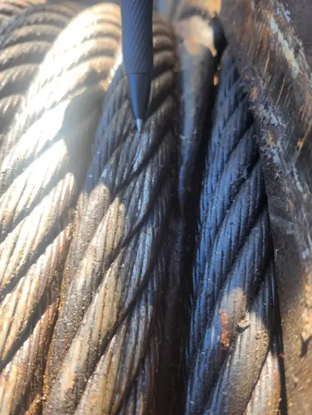 Pen pointing at minor crushing on the bottom-layer rope wraps of a Manitowoc 2250 winch drum