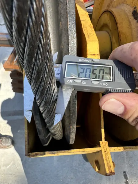 Digital caliper measuring wire rope diameter at the block of an overhead bridge crane