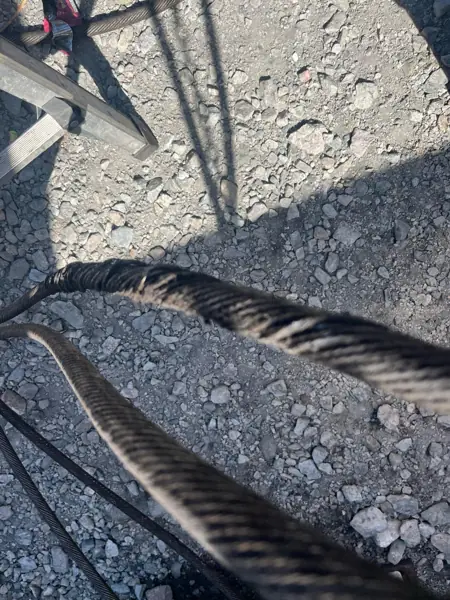 Birdcaged rotation-resistant wire rope from a Terex Explorer 5800 lying on gravel
