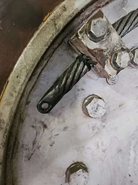 Wire rope end with a welded pulling eye held by a bolted clamp on a winch drum