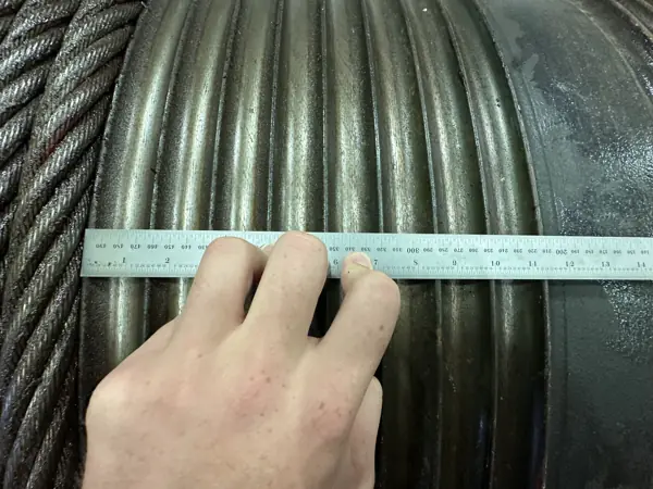 Steel rule across the grooves of a ZPMC ship-to-shore crane drum to measure the groove pitch