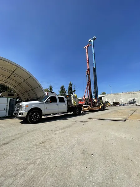 Truck loaded with kelly rope reels beside piling rigs